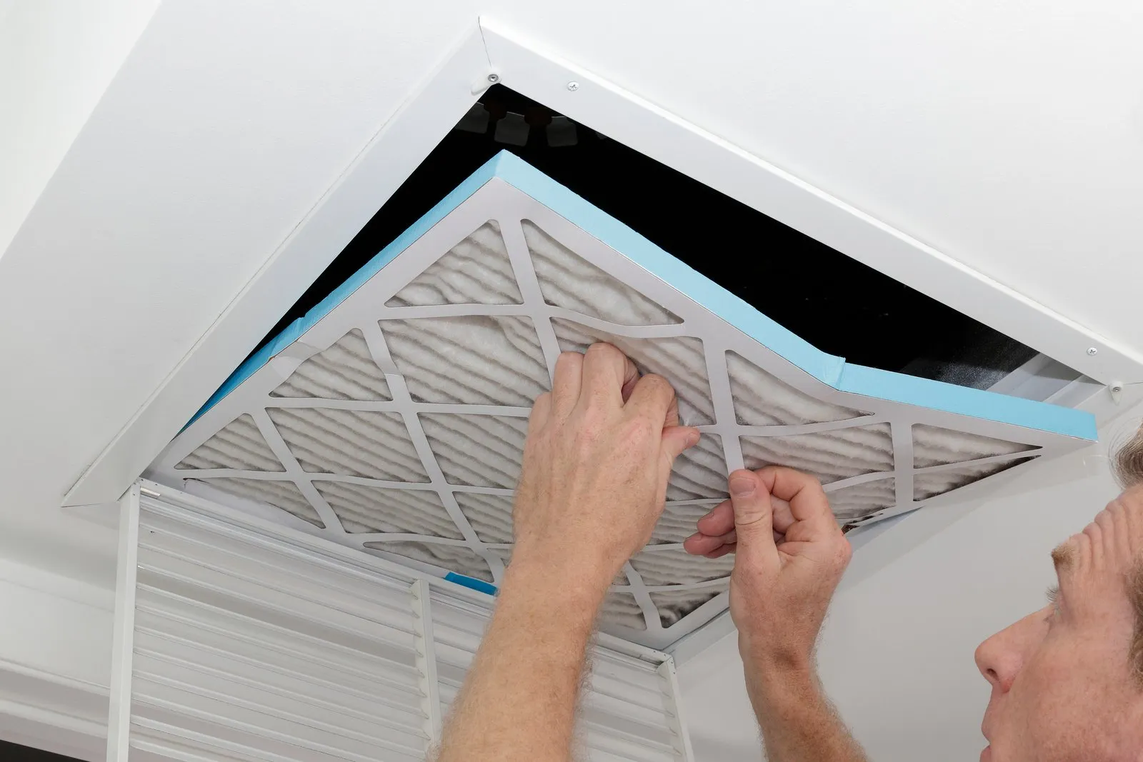 Technician cleaning an air duct vent in a Orange Park home